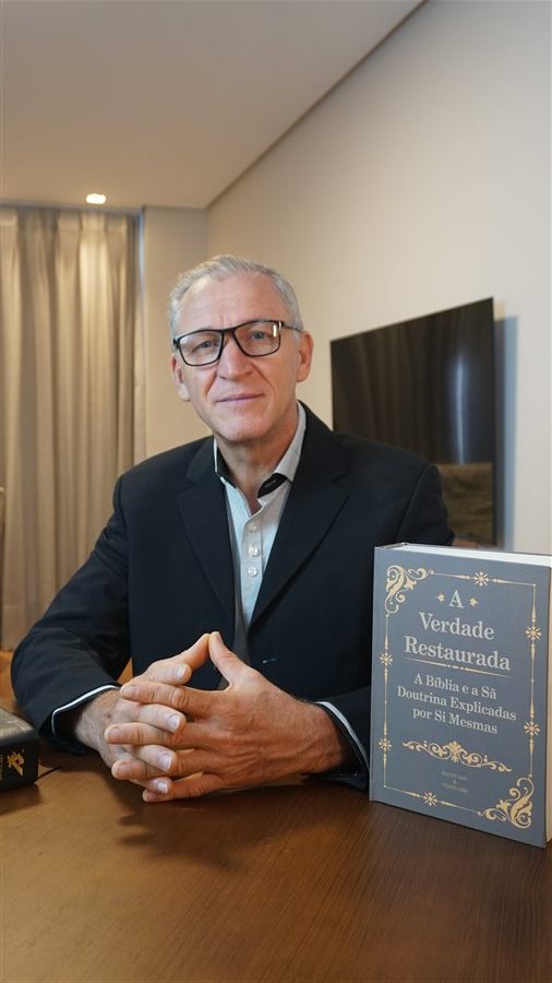 Daniel Ferreira da Rosa segurando o livro A Verdade Restaurada
